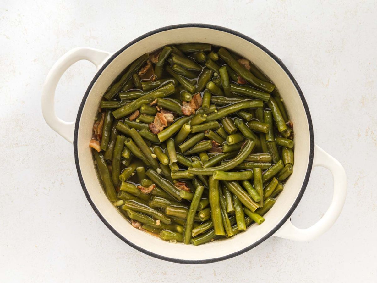 A white cast-iron enamel pot with southern style green beans.