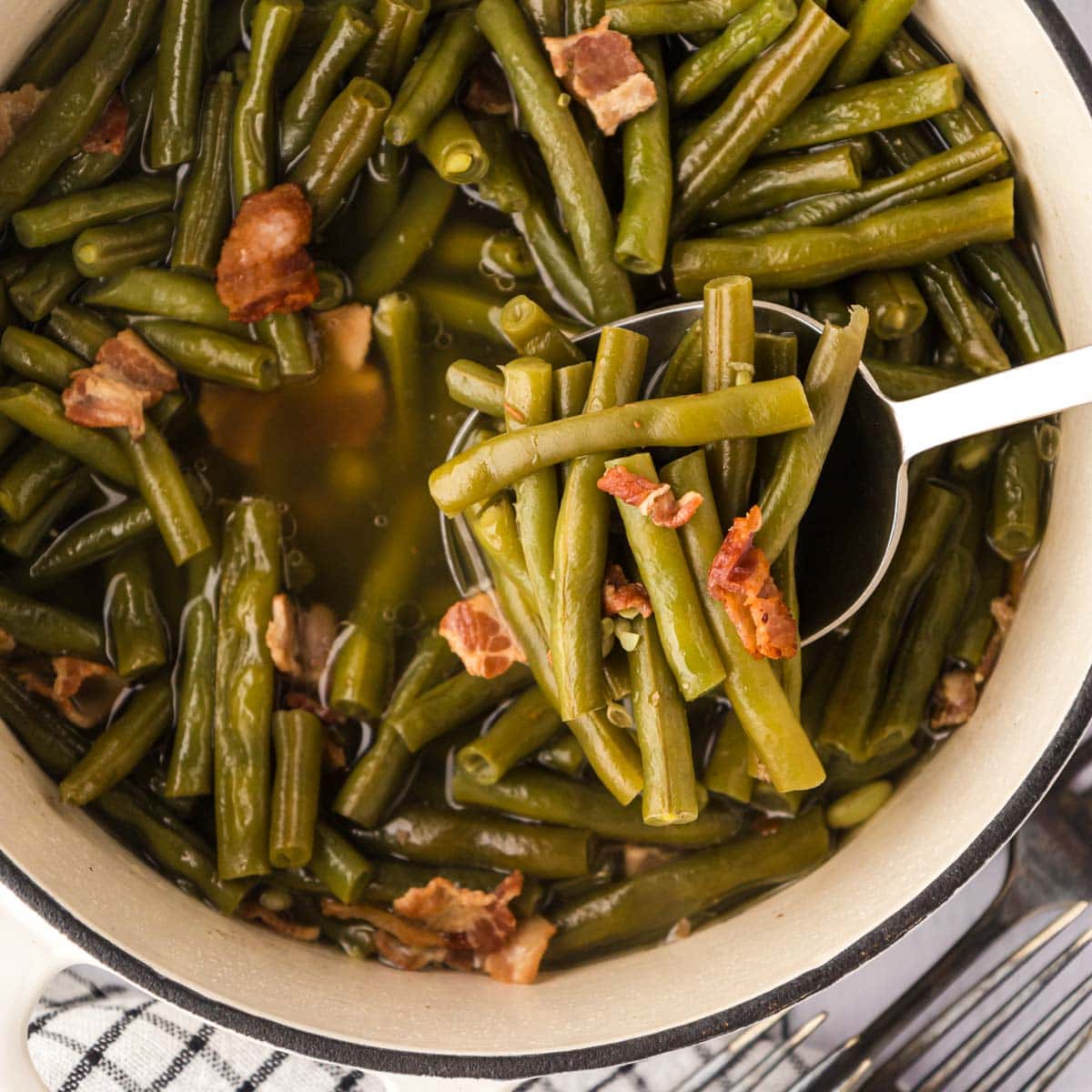 A white cast-iron enamel pot with southern style green beans.