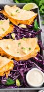 Pin 4 for Buffalo Chicken Tacos are plated with lime slices, purple cabbage and cilantro.