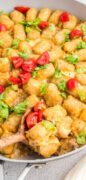 An image only overhead shot of a wooden spoon scooping out a serving of the Big Mac Tater Tot Casserole.