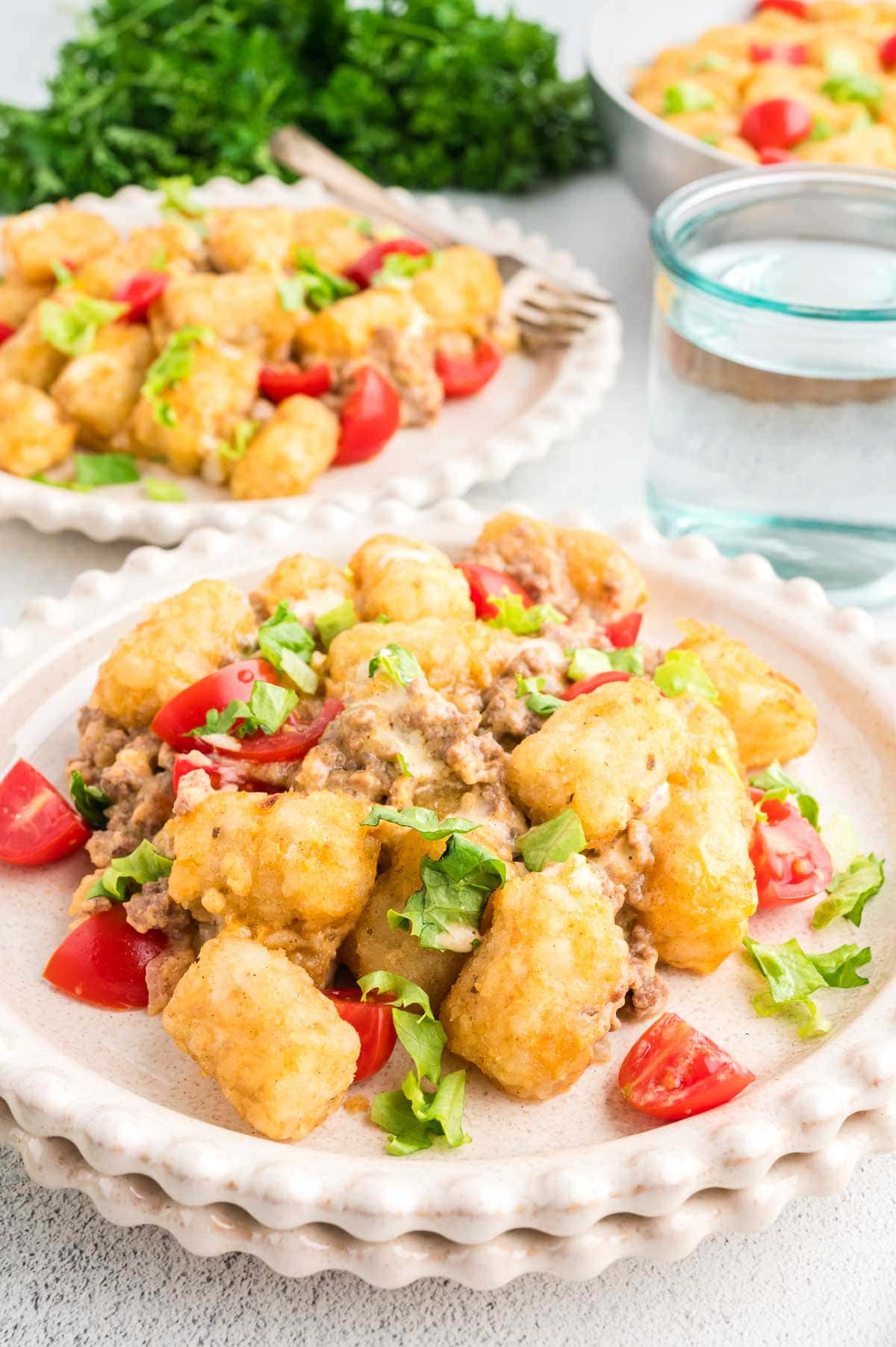 Big mac tater tot casserole portioned out onto plates.