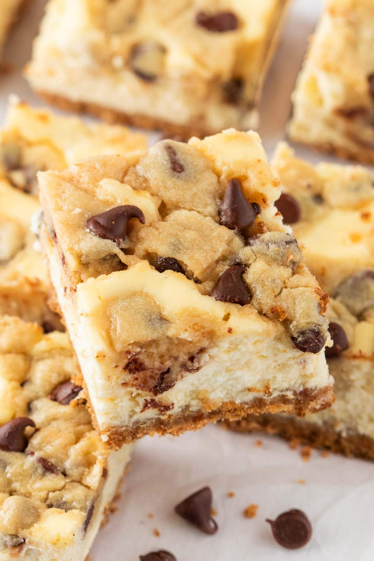 Cheesecake cookie dough bars stacked on top of more bars underneath it.