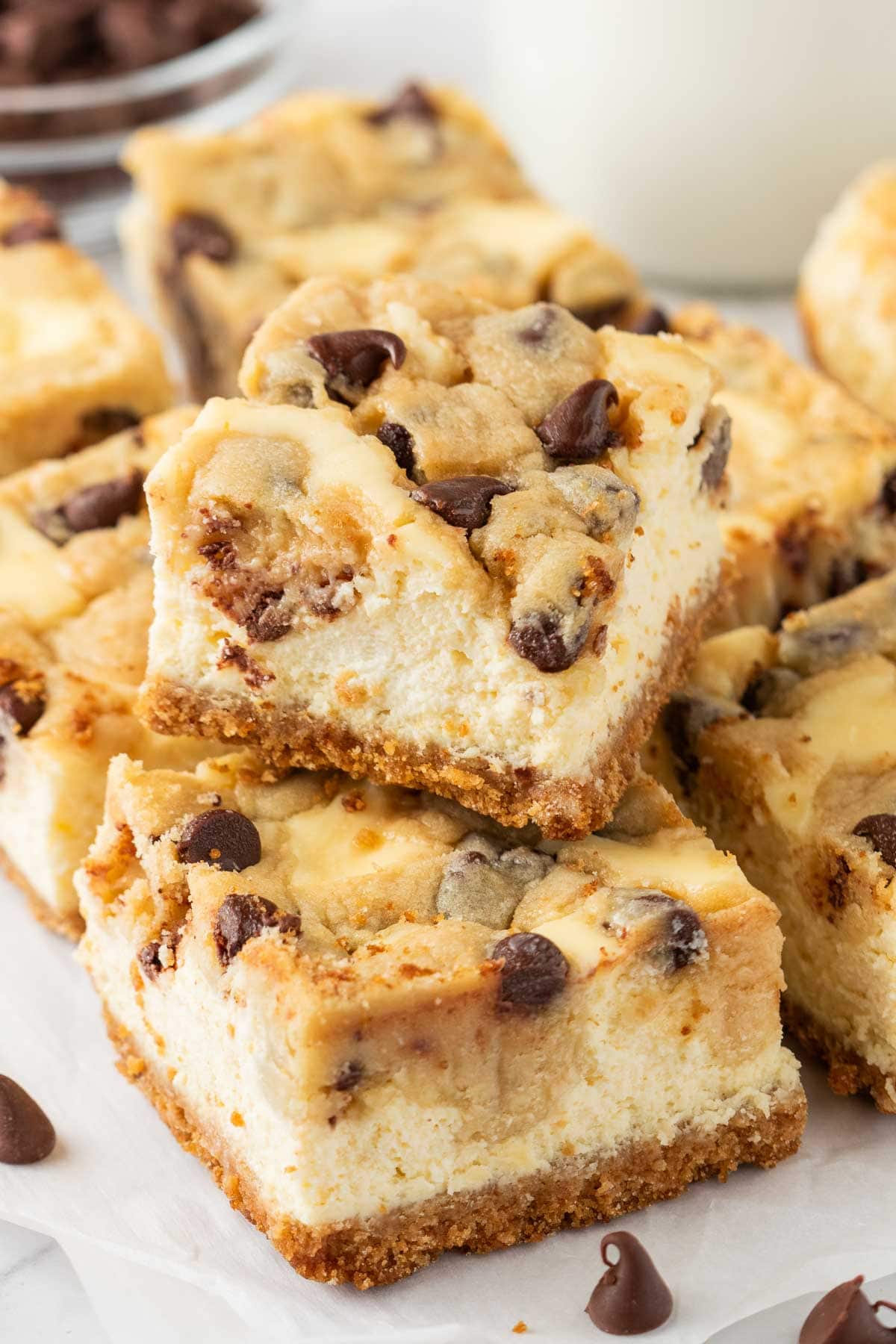 Cookie dough cheesecake bar stacked on top of a row of bars.