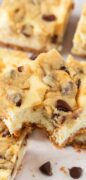 Image only shot is featuring Cookie Dough Cheesecake bars stacked and featured in an overhead shot.