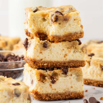 Three cookie dough cheesecake bars stacked on top of eachother.