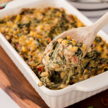 A wooden spoon scooping a serving of Mexican creamed spinach.