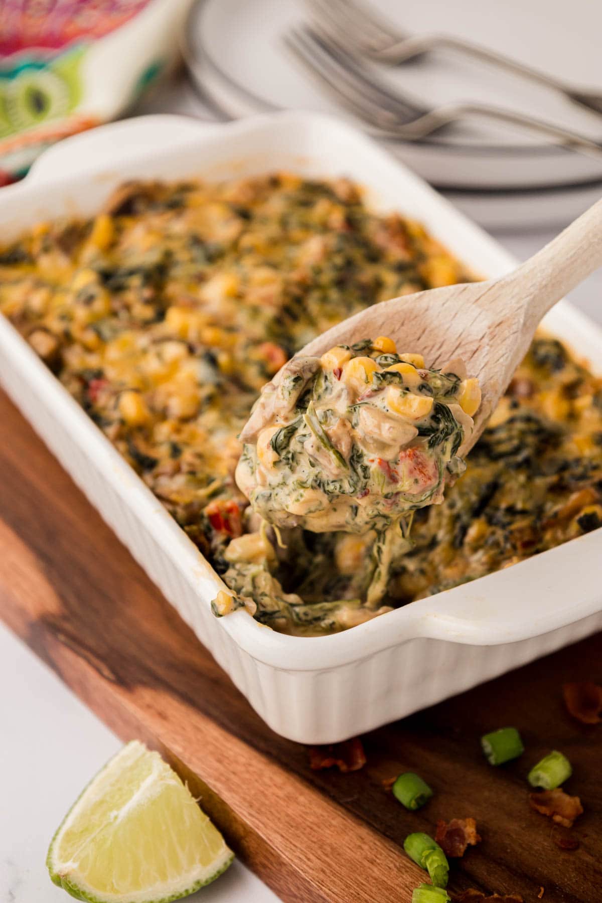 A wooden spoon scooping a serving of Mexican creamed spinach.