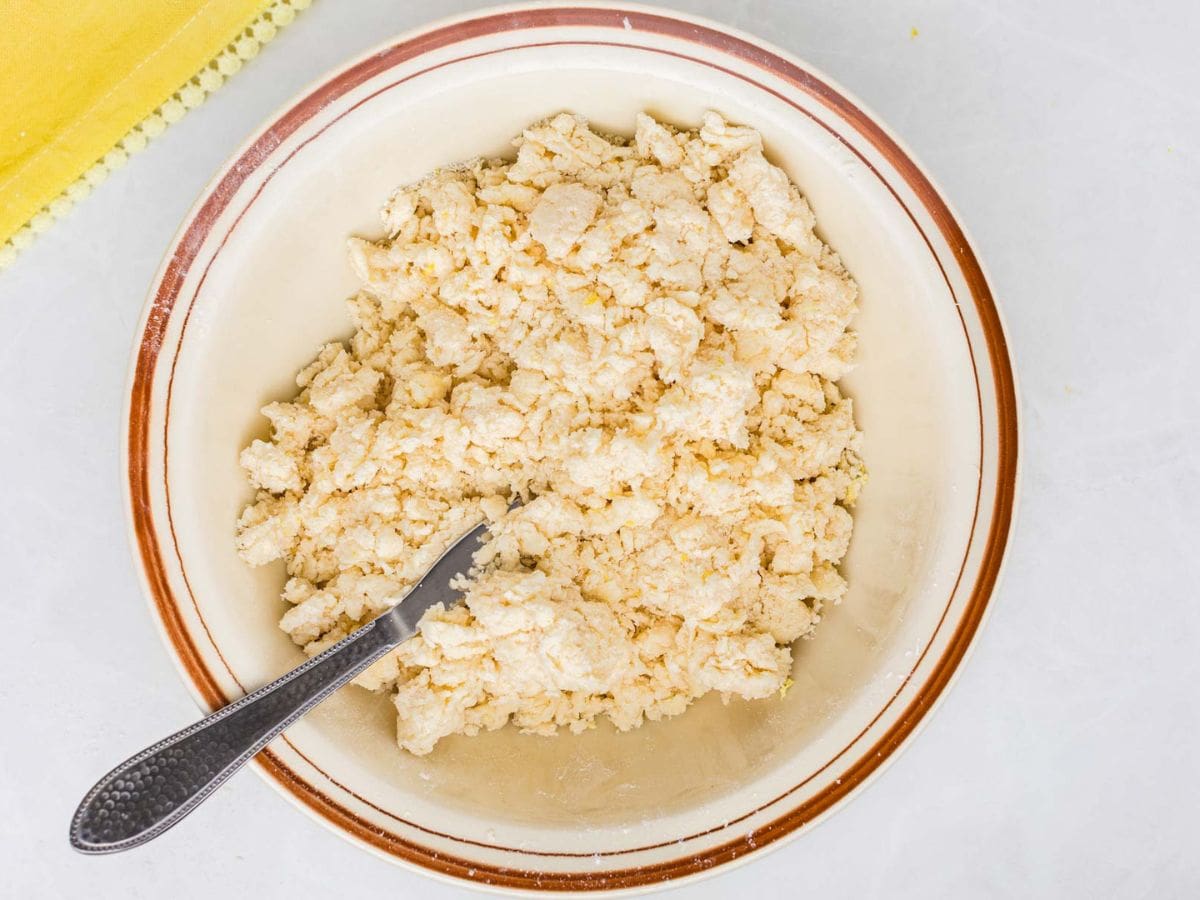 Shaggy scone dough being mixed in a mixing bowl.