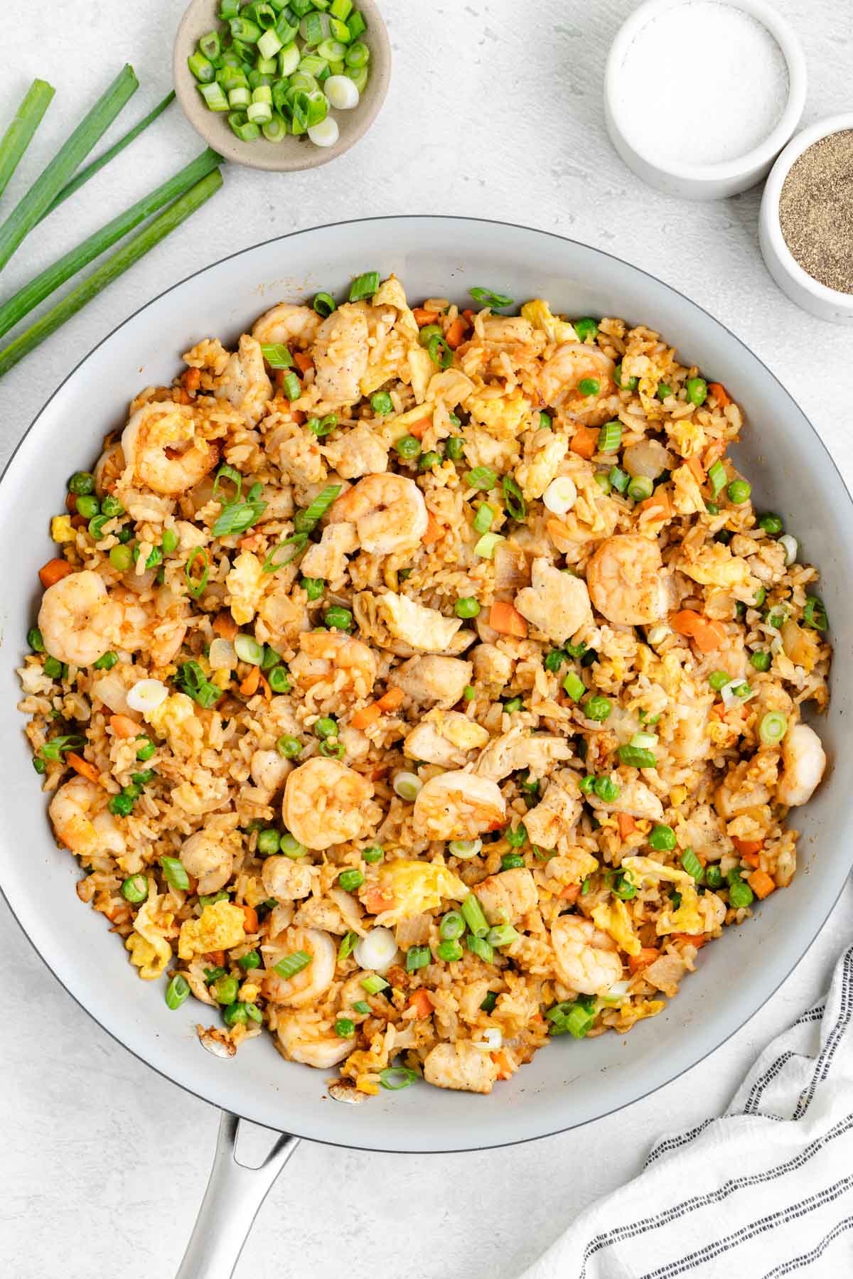 A skillet filled with chicken and shrimp fried rice.