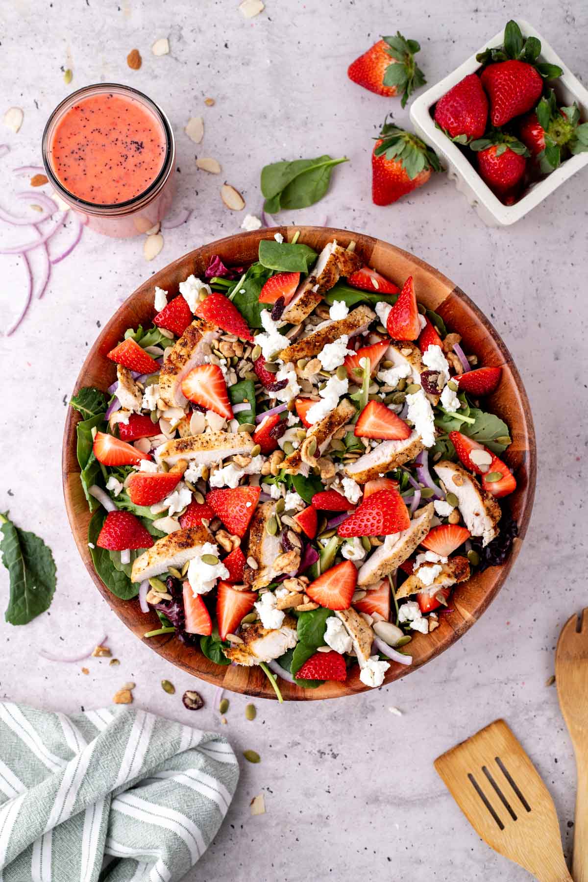 Overhead shot of finished strawberry salad with chicken with the dressing on the side.