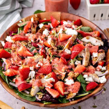 Strawberry salad with chicken and poppy seed dressing served in a large salad bowl.