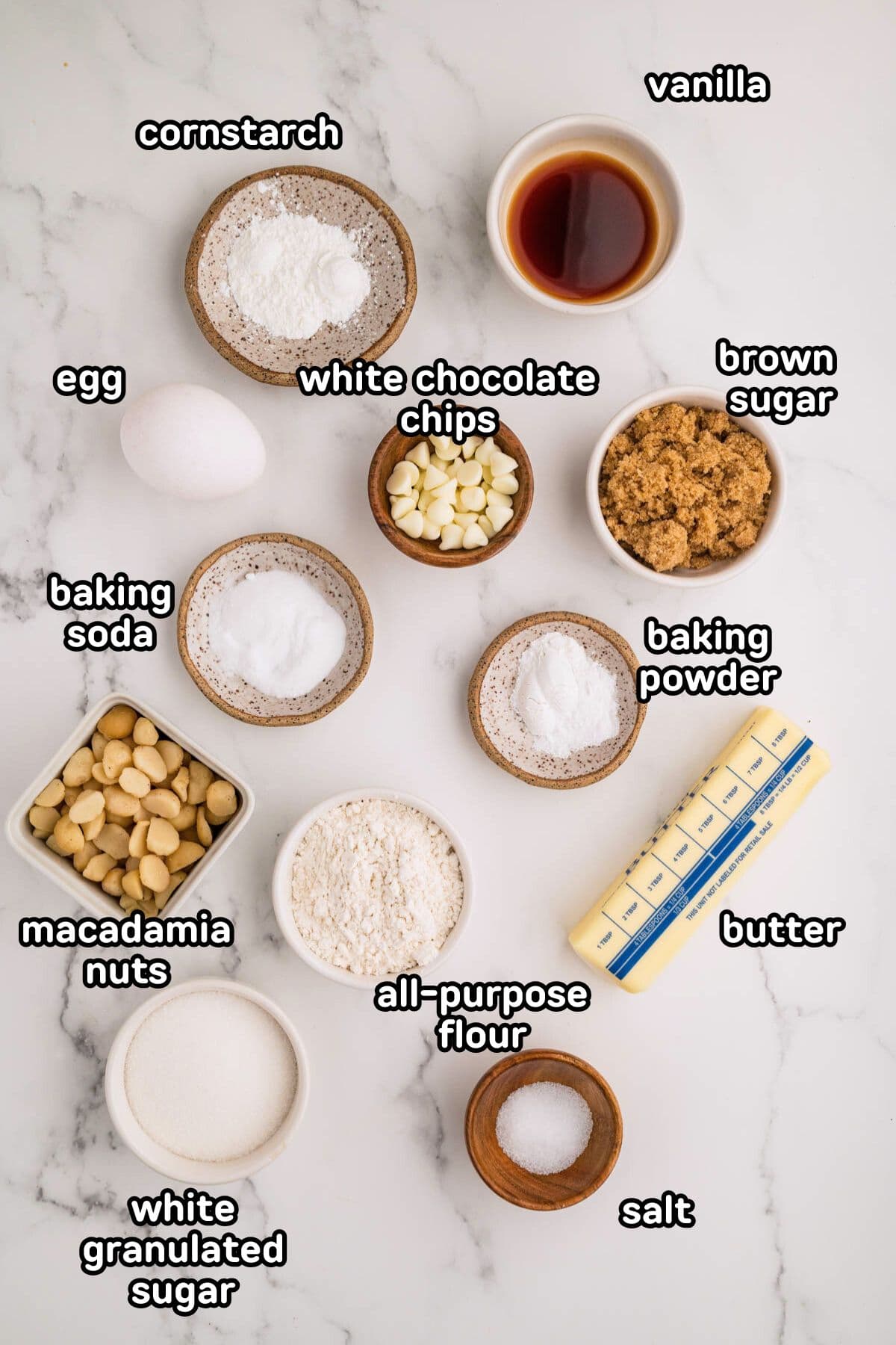 Labeled photo of ingredients needed to make white chocolate macadamia nut cookies.