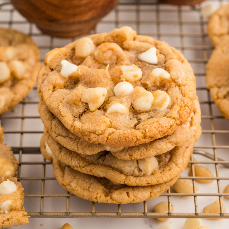 Four cookies stacked on top of each other on top of a cooling rack.