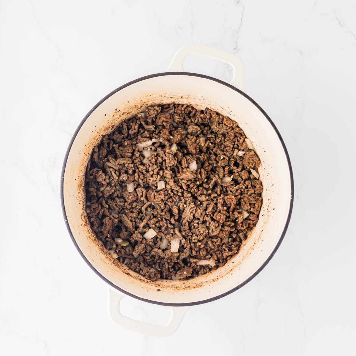 Seasoned ground beef in a Dutch oven.