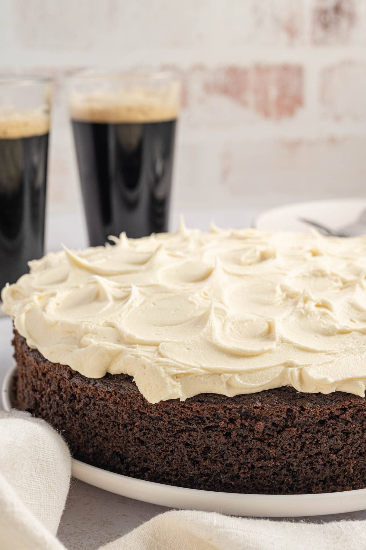 Side view of chocolate stout cake with a fluffy Irish cream buttercream on top.