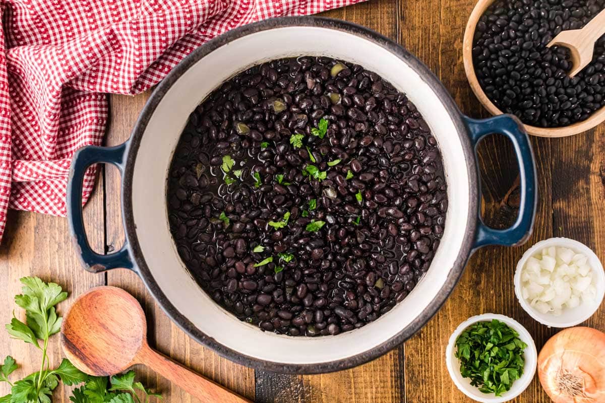 A pot of Cuban style black beans sprinkled with parsley.