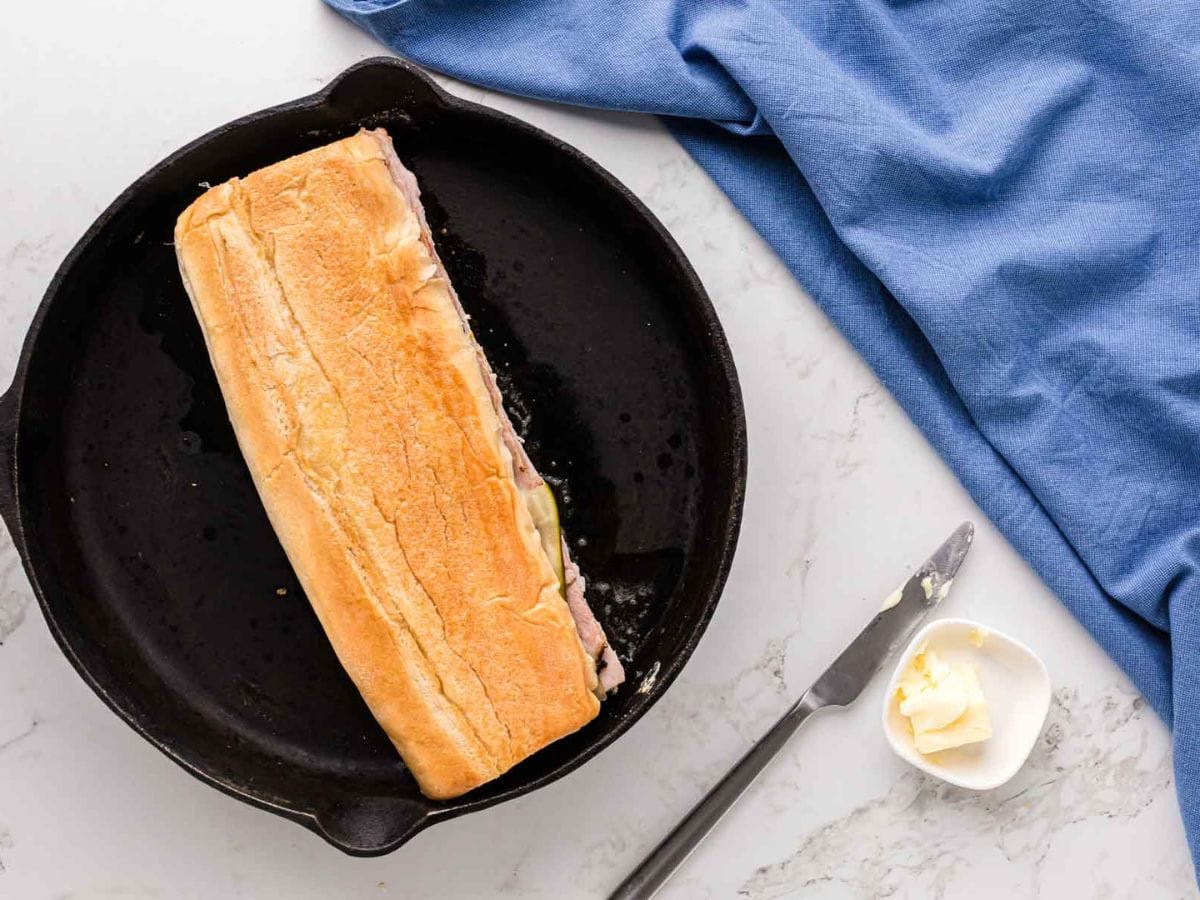 Cuban sandwich in a cast iron pan.