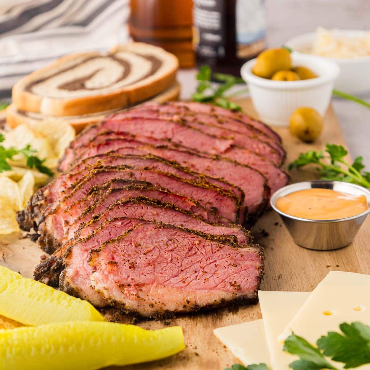 A cutting board with sliced pastrami.