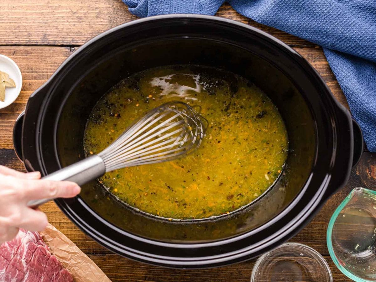 Whisking the sauce together in the slow cooker.