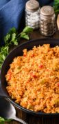 Spanish Yellow rice is featured hot out of the oven in this off centered photo of the pan full.