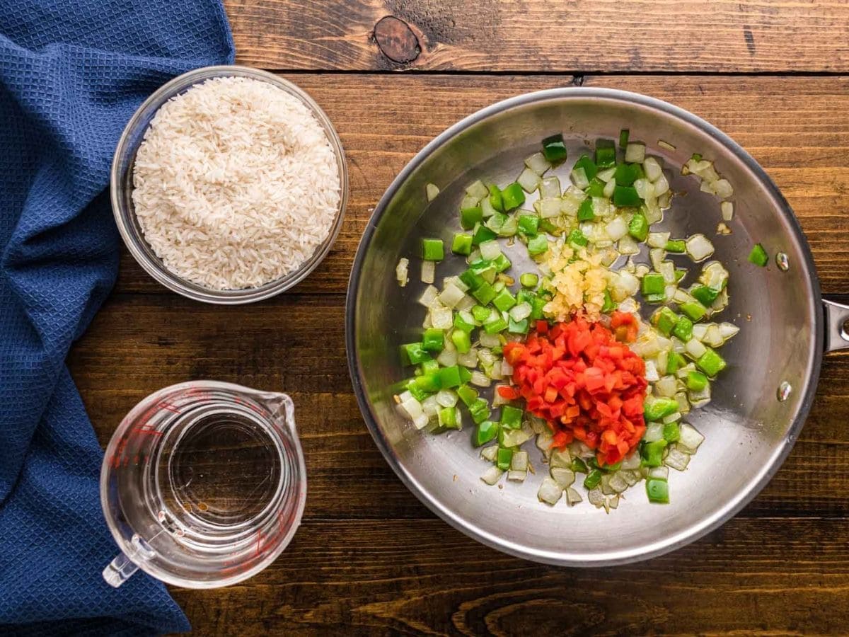 Garlic and pimento added to the skillet of onions and peppers.