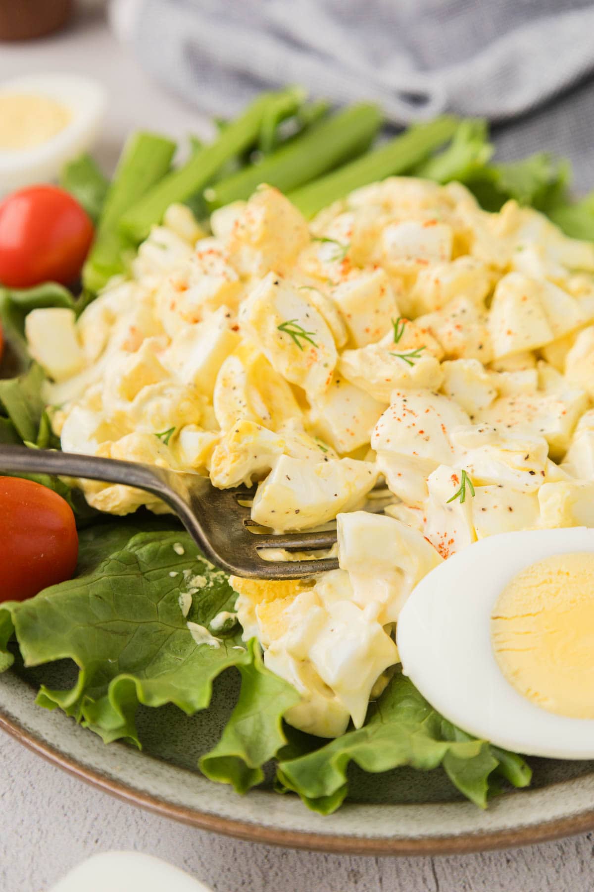 A fork picking up a bite egg salad.