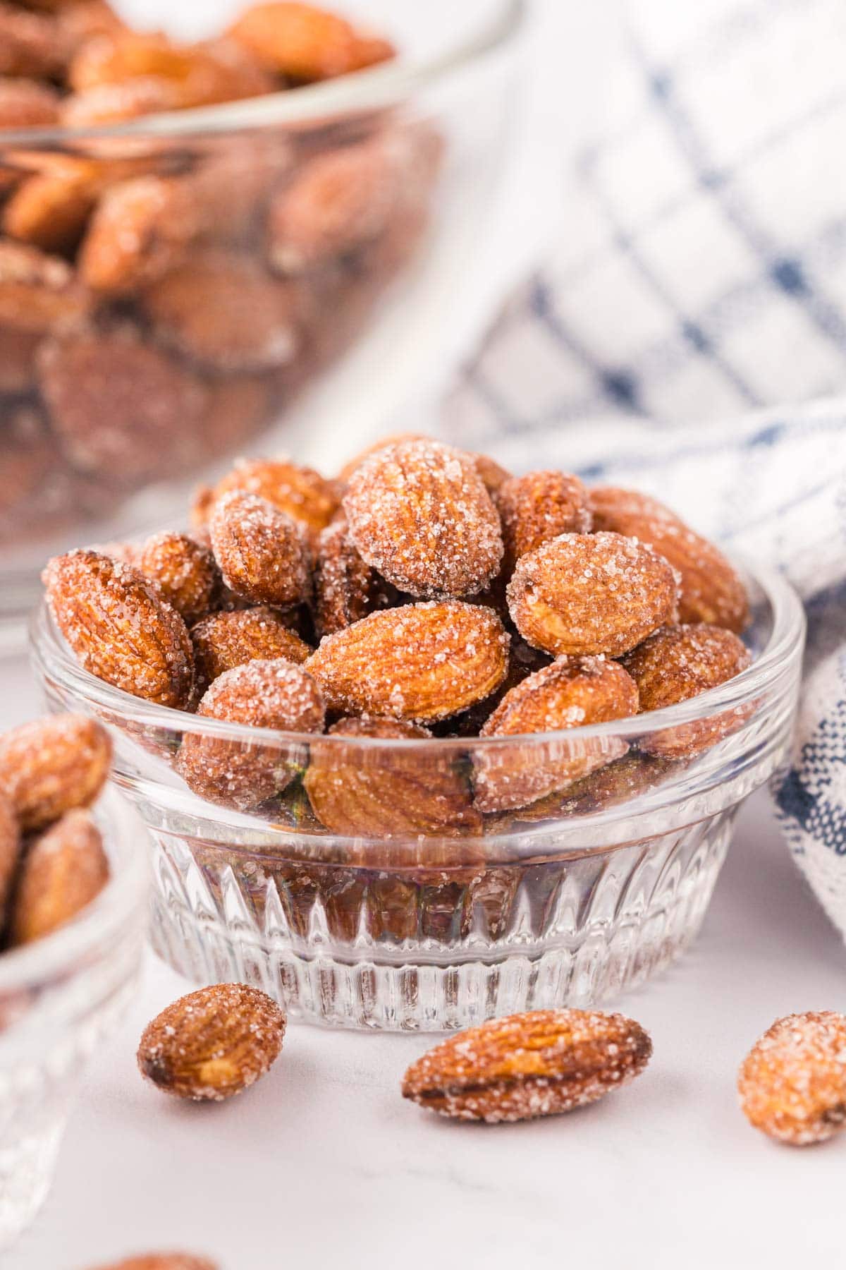 Honey, roasted almonds in a glass dish.