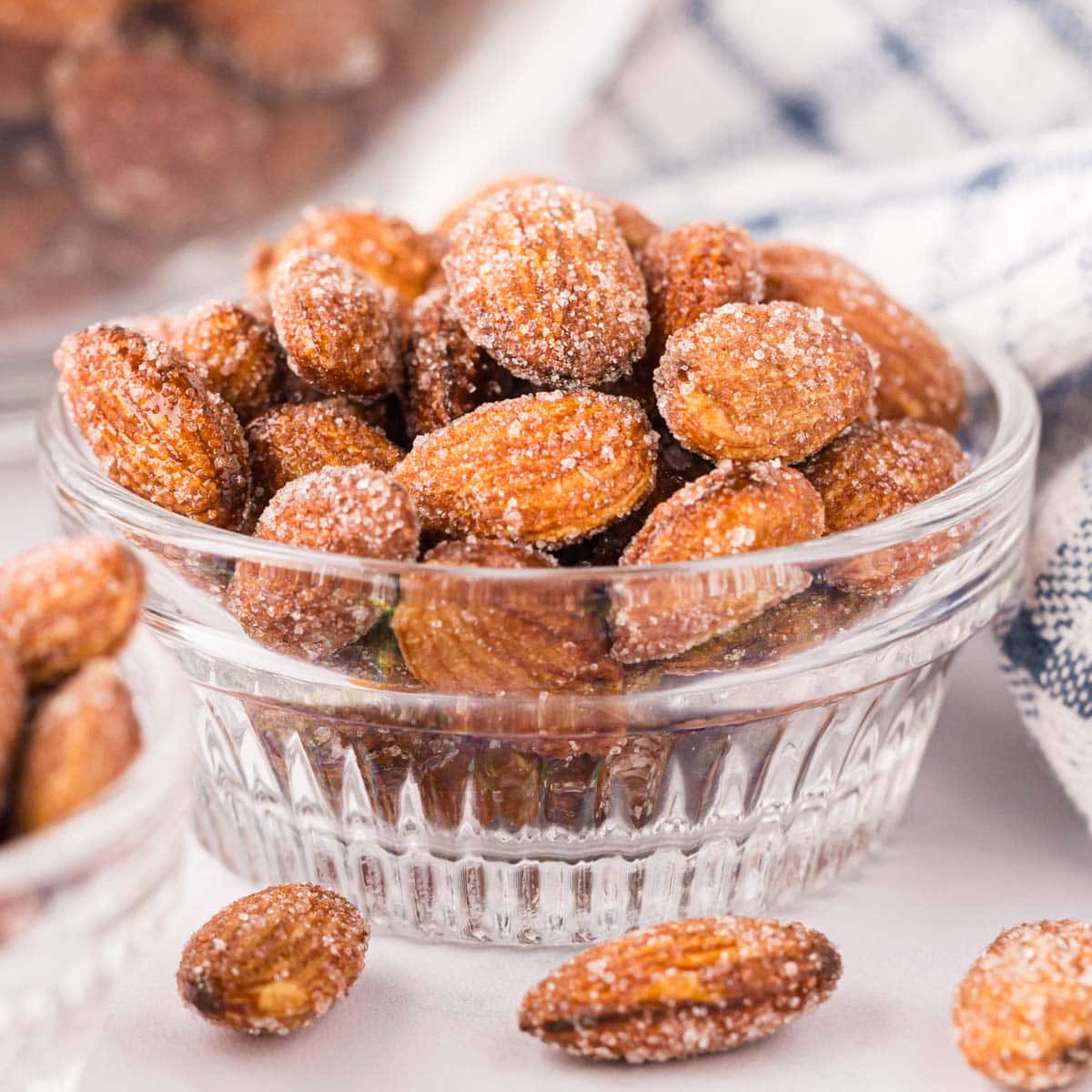 Side view of honey roasted almonds in a glass ramekin.