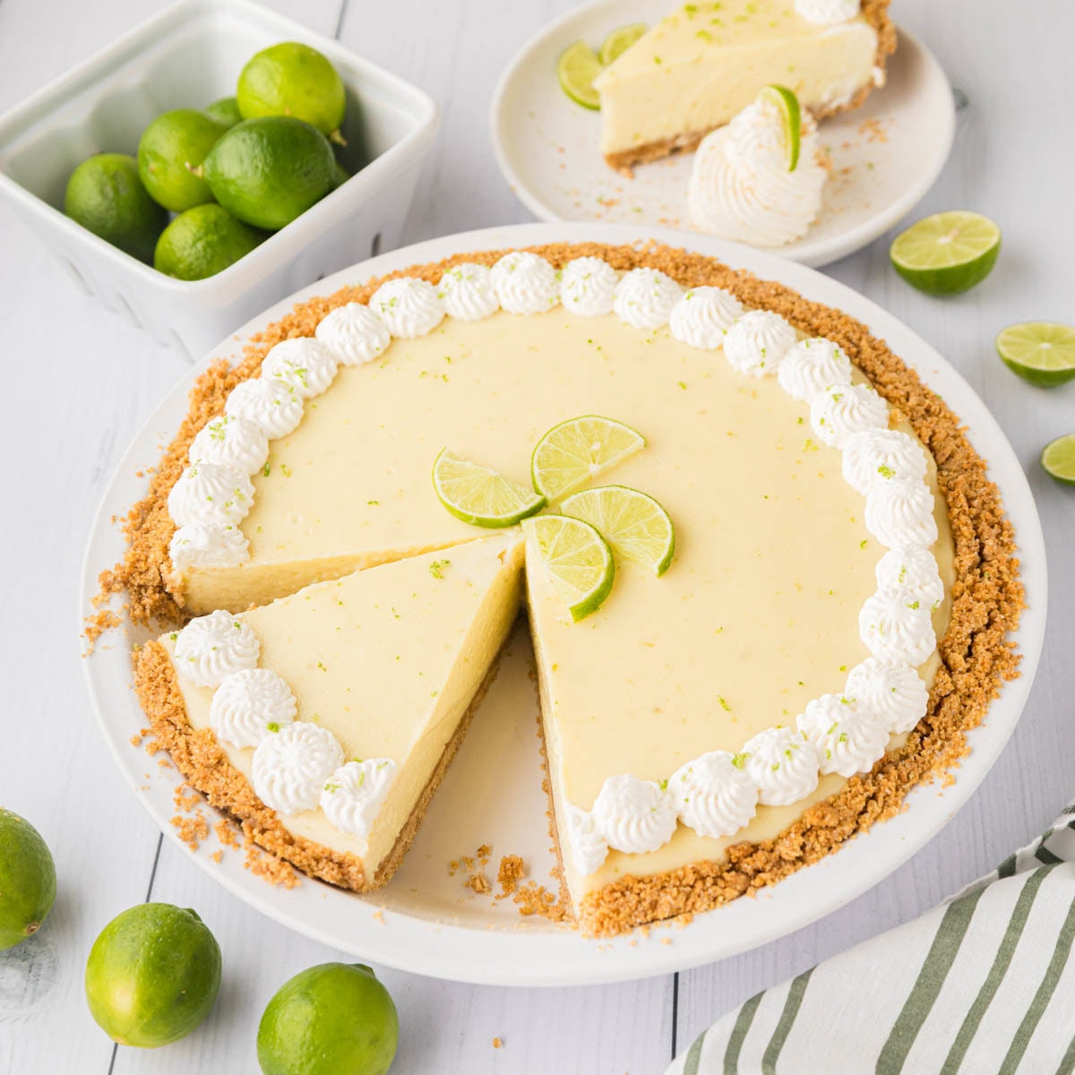 A whole key lime pie cut with a slice removed.