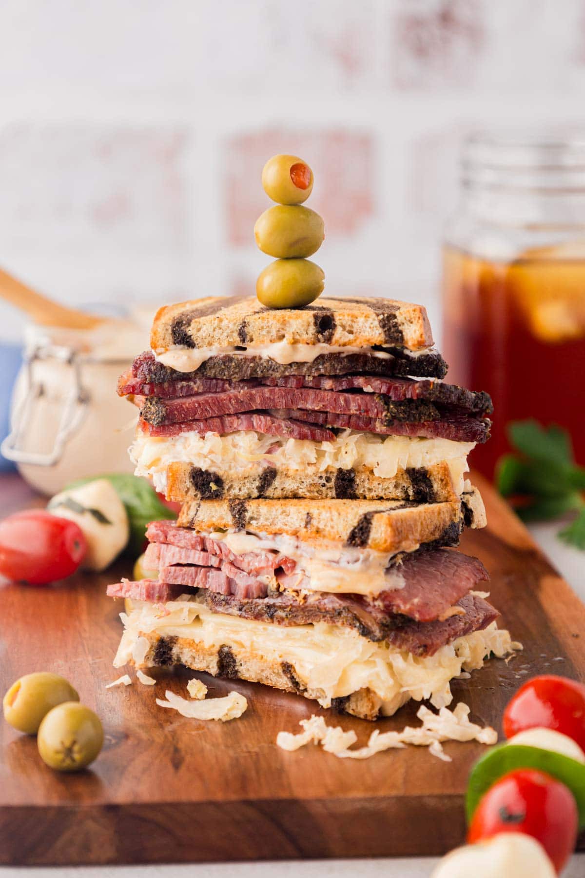 A reuben sandwich on a wood cutting board.