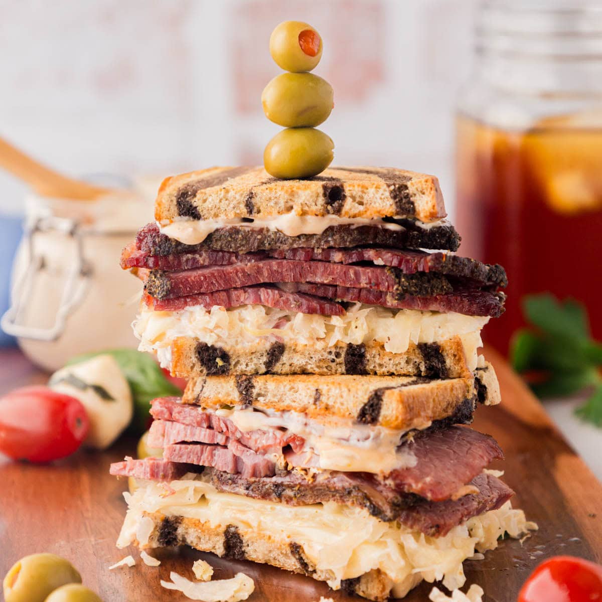 A reuben sandwich on a wood cutting board.