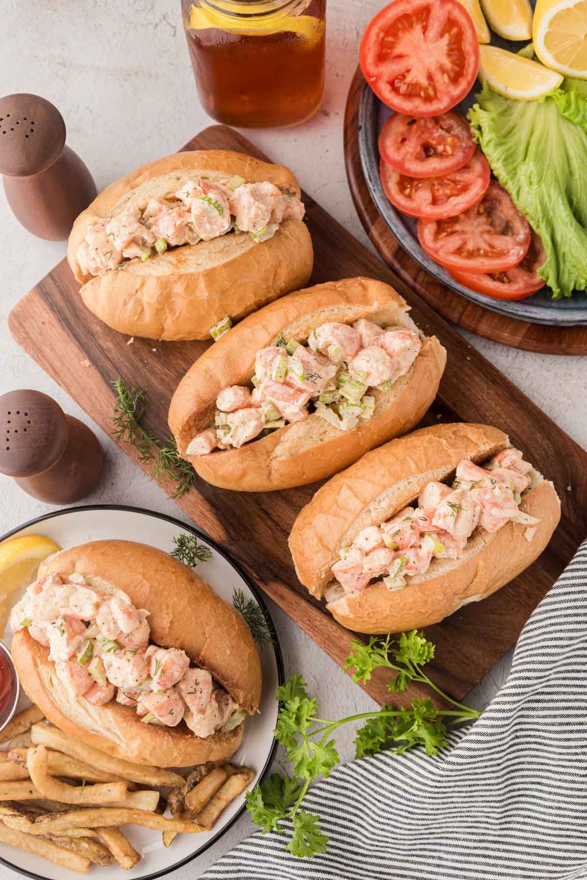 Shrimp salad sandwiches on a wooden serving board.