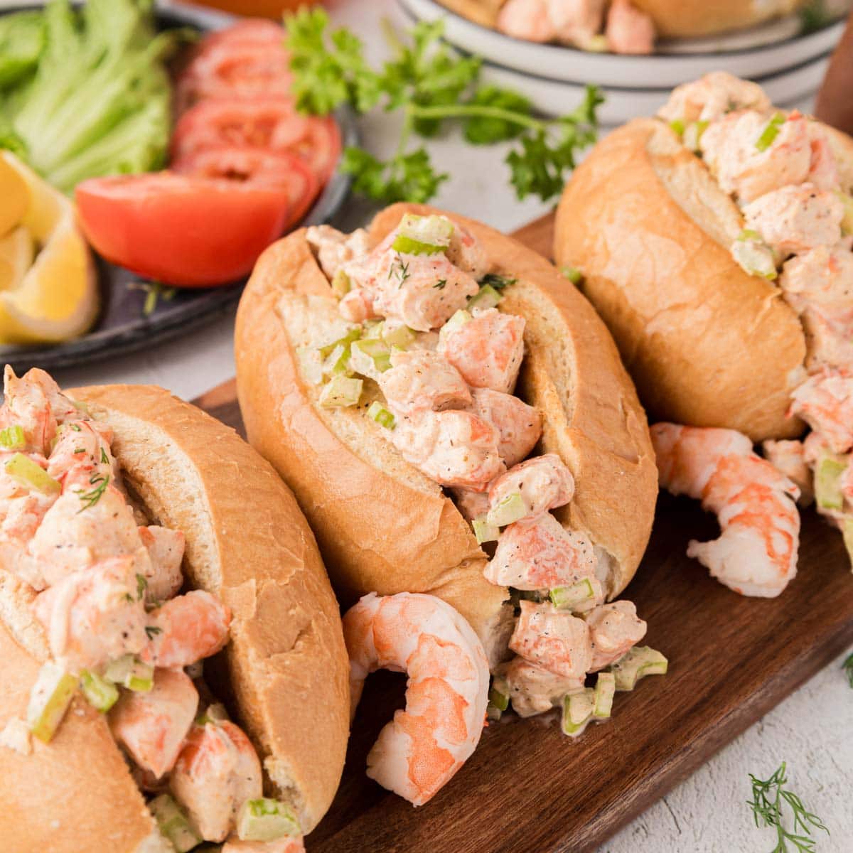 Shrimp salad rolls on a wooden serving board.